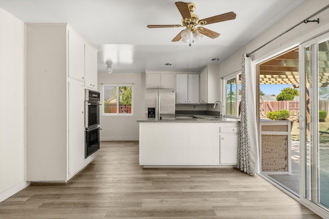 886 Raddue Ave, Santa Barbara, CA 93111 - kitchen featuring stainless steel fridge, a peninsula, light wood-style flooring, and white cabinets