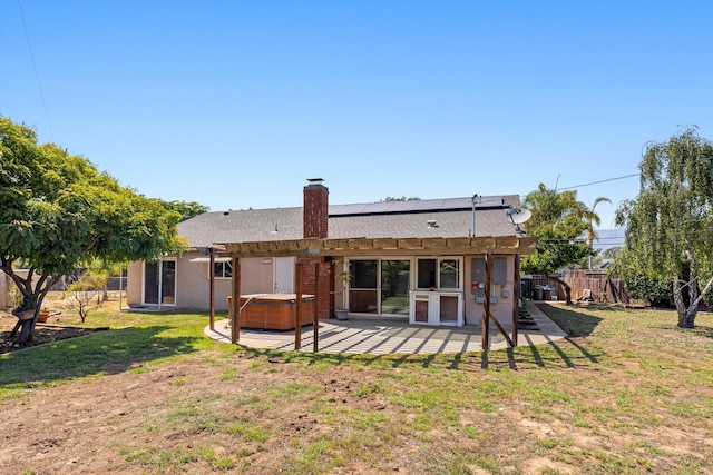 886 Raddue Ave, Santa Barbara, CA 93111 - back of house with a hot tub, roof mounted solar panels, a patio area, a fenced backyard, and a chimney