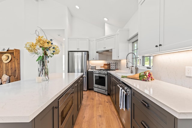 1740 Still Meadow Rd, Solvang, CA 93463 - kitchen featuring stainless steel appliances, light stone countertops, white cabinets, light wood-style flooring, and decorative backsplash