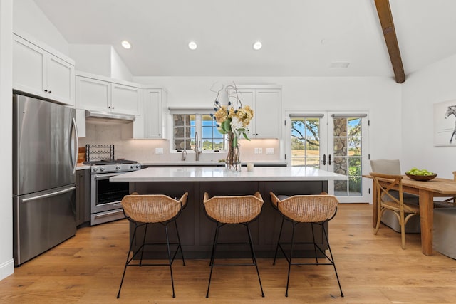 1740 Still Meadow Rd, Solvang, CA 93463 - kitchen featuring stainless steel appliances, under cabinet range hood, white cabinetry, a kitchen bar, and backsplash