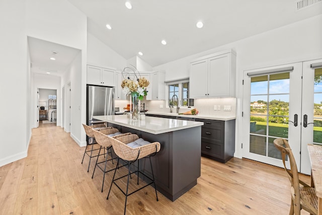 1740 Still Meadow Rd, Solvang, CA 93463 - kitchen with a kitchen island, a kitchen breakfast bar, french doors, light countertops, and light wood-style floors