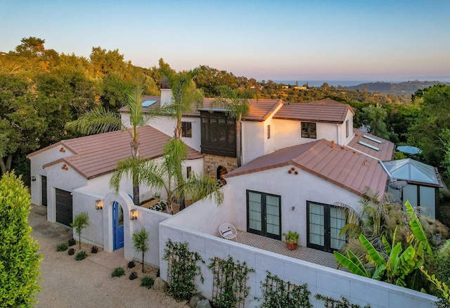 2641 Dorking Pl, Santa Barbara, CA 93105 - mediterranean / spanish home with french doors, stucco siding, an attached garage, and a tiled roof