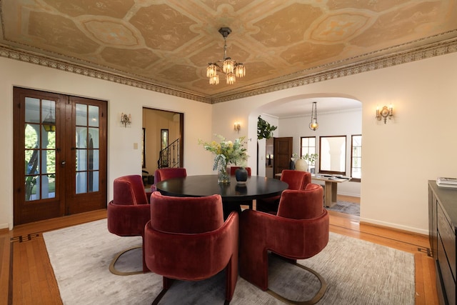 205 S Lomita Ave, Ojai, CA 93023 - dining space with arched walkways, light wood finished floors, a chandelier, french doors, and an ornate ceiling
