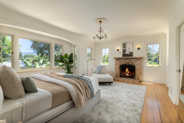 205 S Lomita Ave, Ojai, CA 93023 - bedroom with light wood-type flooring, a chandelier, and a fireplace
