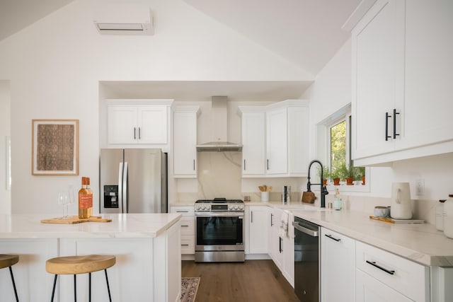 251 Cloydon Cir, Montecito, CA 93108 - kitchen with stainless steel appliances, wall chimney range hood, vaulted ceiling, a kitchen bar, and white cabinets