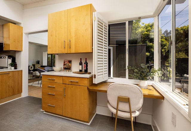 1330 W Valerio St, Santa Barbara, CA 93101 - kitchen featuring healthy amount of natural light, dark tile patterned flooring, light countertops, and built in study area