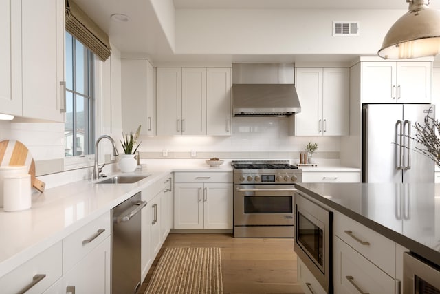 3718 State St Unit 314, Santa Barbara, CA 93105 - kitchen with high end appliances, wall chimney range hood, white cabinets, wine cooler, and wood finished floors
