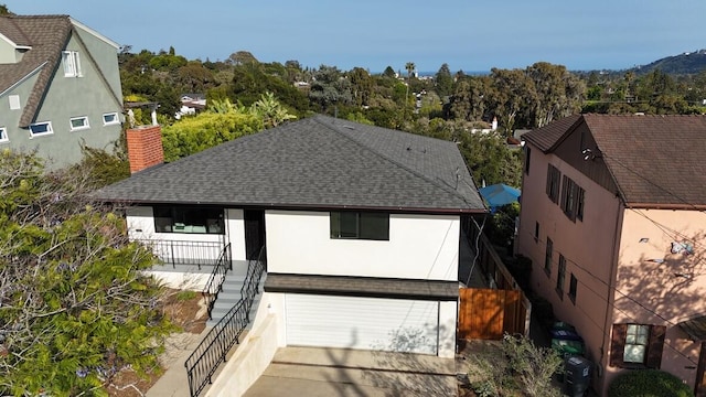 19 W Quinto St, Santa Barbara, CA 93105 - rear view of house with roof with shingles, a chimney, stairs, an attached garage, and stucco siding