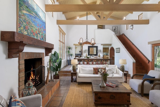 601 San Ysidro Rd, Santa Barbara, CA 93108 - tiled living room with high vaulted ceiling, beam ceiling, a brick fireplace, stairway, and arched walkways