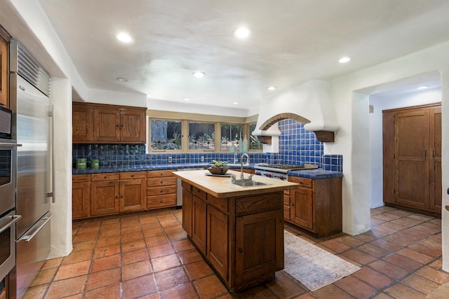 601 San Ysidro Rd, Santa Barbara, CA 93108 - kitchen featuring a center island with sink, tasteful backsplash, stainless steel appliances, brown cabinets, and recessed lighting