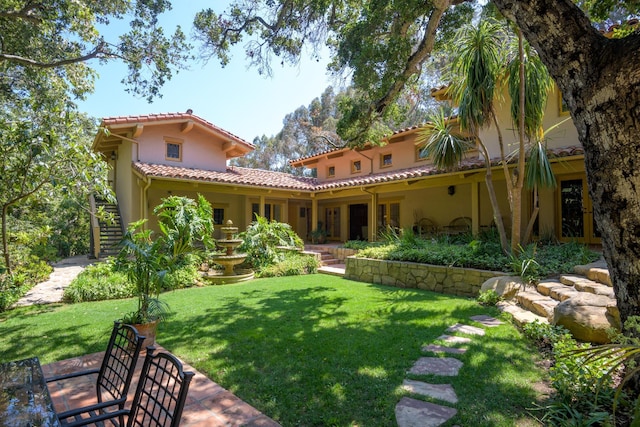 601 San Ysidro Rd, Santa Barbara, CA 93108 - rear view of house featuring a lawn, stucco siding, and a tiled roof