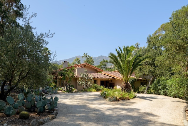 601 San Ysidro Rd, Santa Barbara, CA 93108 - mediterranean / spanish-style house featuring a mountain view, stucco siding, a tiled roof, a chimney, and driveway