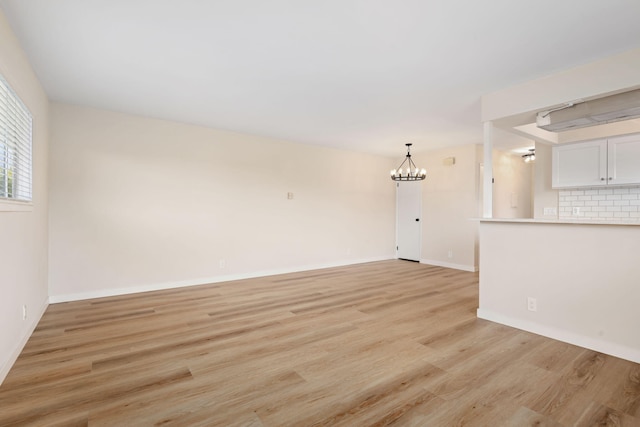 5925 Birch St Unit 4, Carpinteria, CA 93013 - unfurnished living room featuring a chandelier and light wood-type flooring