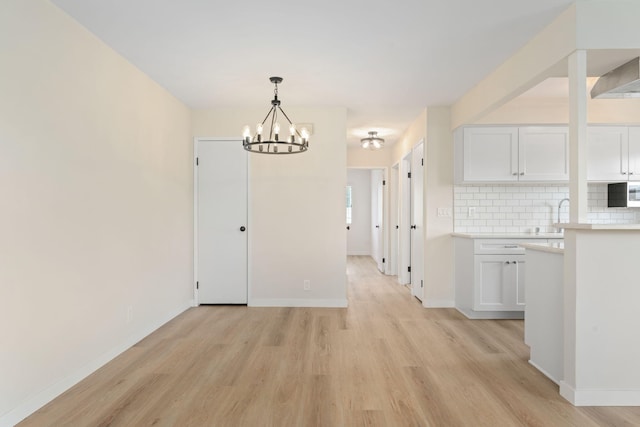 5925 Birch St Unit 4, Carpinteria, CA 93013 - unfurnished dining area with light wood finished floors and a chandelier