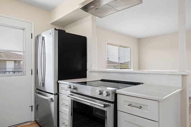 5925 Birch St Unit 4, Carpinteria, CA 93013 - kitchen with appliances with stainless steel finishes, exhaust hood, white cabinetry, and light countertops