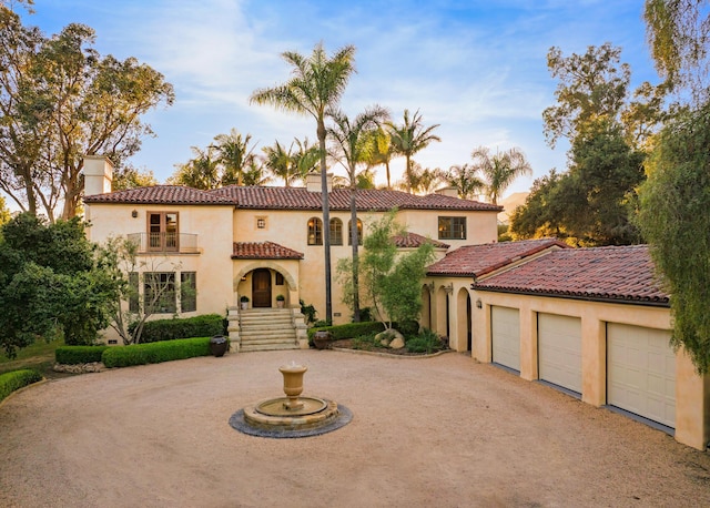 771 Via Manana, Montecito, CA 93108 - mediterranean / spanish house featuring curved driveway, a balcony, stucco siding, a garage, and a chimney