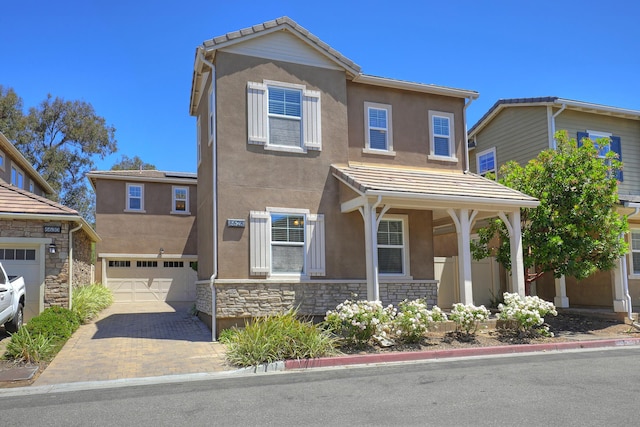 6628 Sand Castle Pl Unit C-7, Goleta, CA 93117 - view of front of home with stucco siding, an attached garage, stone siding, decorative driveway, and a tile roof