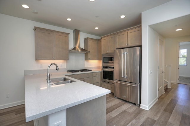 6628 Sand Castle Pl Unit C-7, Goleta, CA 93117 - kitchen with stainless steel appliances, wall chimney range hood, a peninsula, light wood-type flooring, and recessed lighting