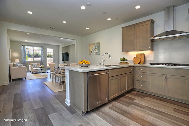 6628 Sand Castle Pl Unit C-7, Goleta, CA 93117 - kitchen with wall chimney range hood, stainless steel dishwasher, gas cooktop, open floor plan, and a peninsula