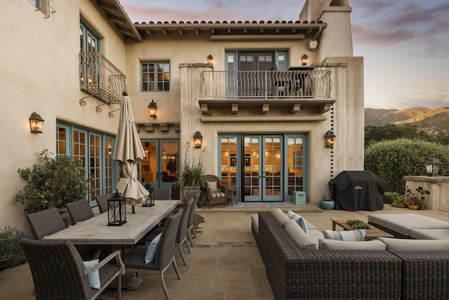 1439 Tunnel Rd, Santa Barbara, CA 93105 - back of property at dusk featuring a balcony, french doors, a patio area, and outdoor dining space