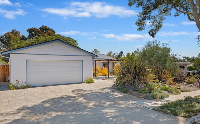 7234 Del Norte Dr, Goleta, CA 93117 - view of front of home with roof mounted solar panels, decorative driveway, stucco siding, and an attached garage