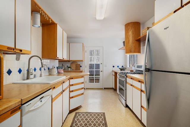 7234 Del Norte Dr, Goleta, CA 93117 - kitchen with appliances with stainless steel finishes, backsplash, white cabinets, and open shelves