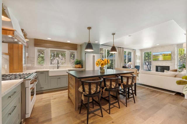 2807 Gaviota St, Los Olivos, CA 93441 - kitchen featuring white appliances, exhaust hood, a breakfast bar area, decorative backsplash, and light wood-style flooring