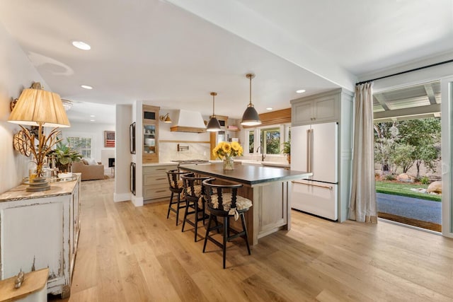 2807 Gaviota St, Los Olivos, CA 93441 - kitchen with freestanding refrigerator, custom exhaust hood, a kitchen bar, light wood-style flooring, and recessed lighting