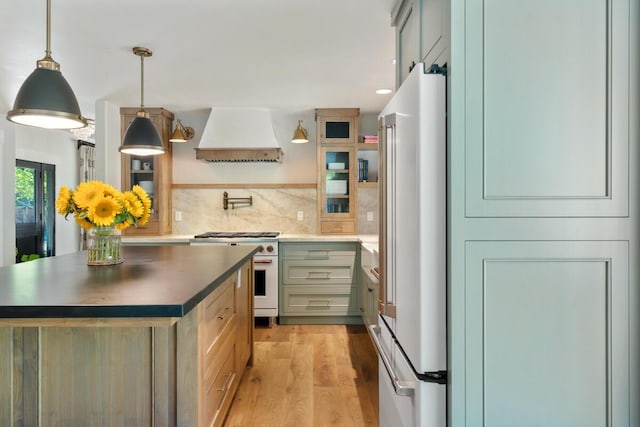 2807 Gaviota St, Los Olivos, CA 93441 - kitchen with premium appliances, custom range hood, light wood-type flooring, tasteful backsplash, and dark countertops