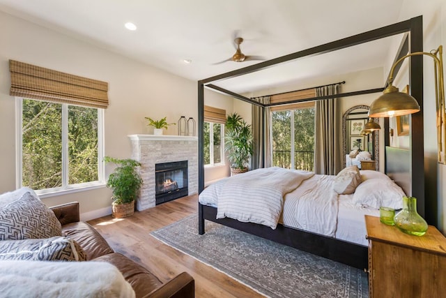 2807 Gaviota St, Los Olivos, CA 93441 - bedroom with multiple windows, a glass covered fireplace, wood finished floors, recessed lighting, and a ceiling fan