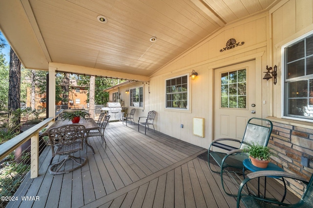 wooden terrace featuring outdoor dining space and grilling area