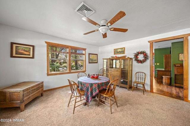 dining space featuring baseboards, ceiling fan, visible vents, and light colored carpet