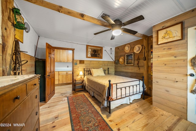 bedroom with light wood finished floors and wooden walls