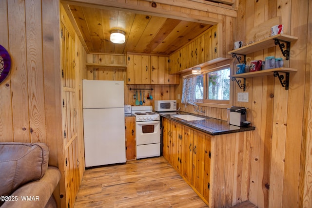 1862 Douglas Fir Dr, Pinetop, AZ 85935 - kitchen with white appliances, a sink, open shelves, wooden walls, and dark countertops