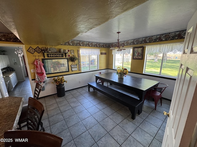 7525 E E Sherwood Rd, Snowflake, AZ 85937 - tiled dining space with healthy amount of natural light, a textured ceiling, and wainscoting
