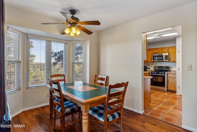 dining area featuring baseboards, plenty of natural light, and a ceiling fan