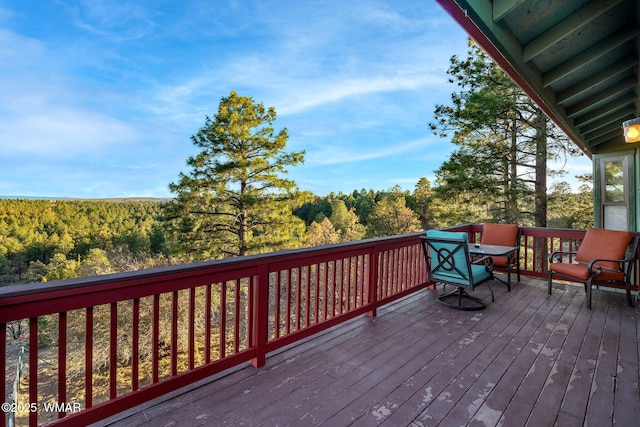 wooden deck featuring a forest view