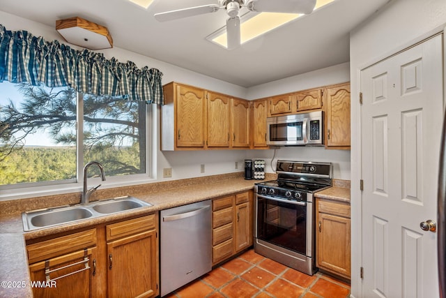 kitchen with a ceiling fan, a sink, light countertops, stainless steel appliances, and light tile patterned flooring