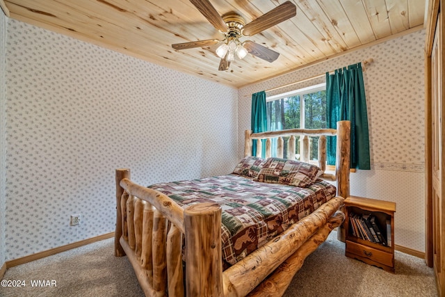 carpeted bedroom with wooden ceiling, ceiling fan, baseboards, and wallpapered walls