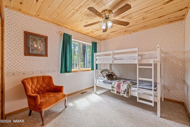 carpeted bedroom with baseboards, wooden ceiling, visible vents, and wallpapered walls