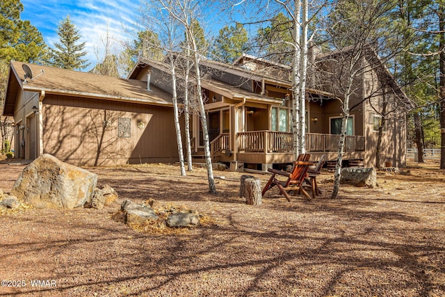 rear view of house featuring a garage and a wooden deck