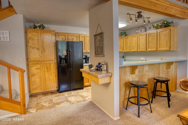 5712 Spruce Cir, Pinetop, AZ 85935 - kitchen with light colored carpet, a breakfast bar, a peninsula, light countertops, and black fridge