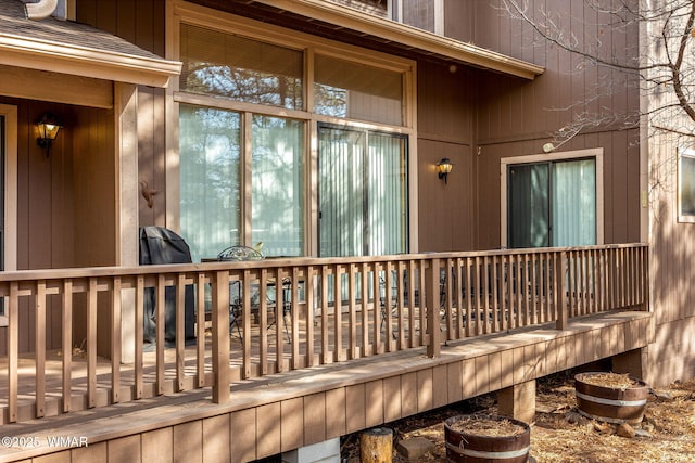 entrance to property featuring roof with shingles and a wooden deck