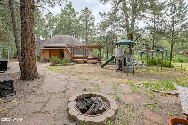 community jungle gym with an outdoor fire pit and a pergola
