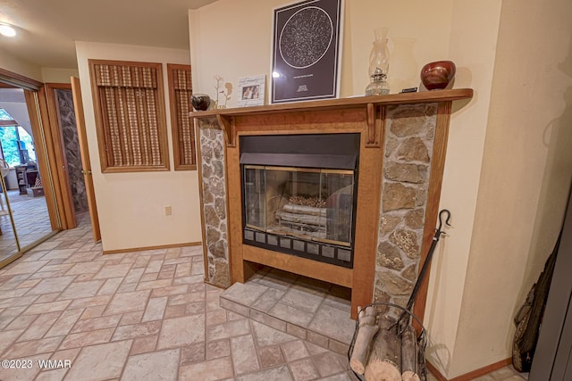 interior details with baseboards and a glass covered fireplace