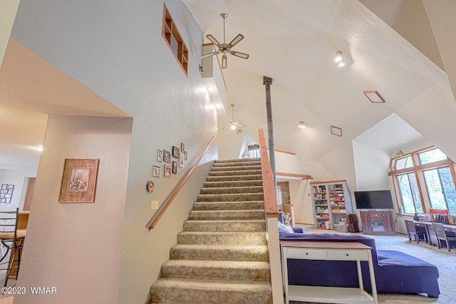stairs featuring high vaulted ceiling, carpet, and a ceiling fan