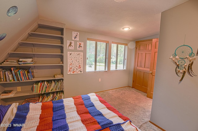 carpeted bedroom featuring a closet, vaulted ceiling, a textured ceiling, and baseboards