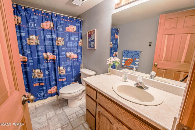 full bath with toilet, stone tile floors, visible vents, and vanity