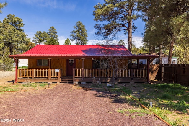 view of front of house with metal roof and fence