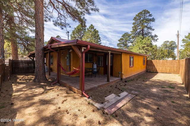 rear view of property with a fenced backyard and a wooden deck